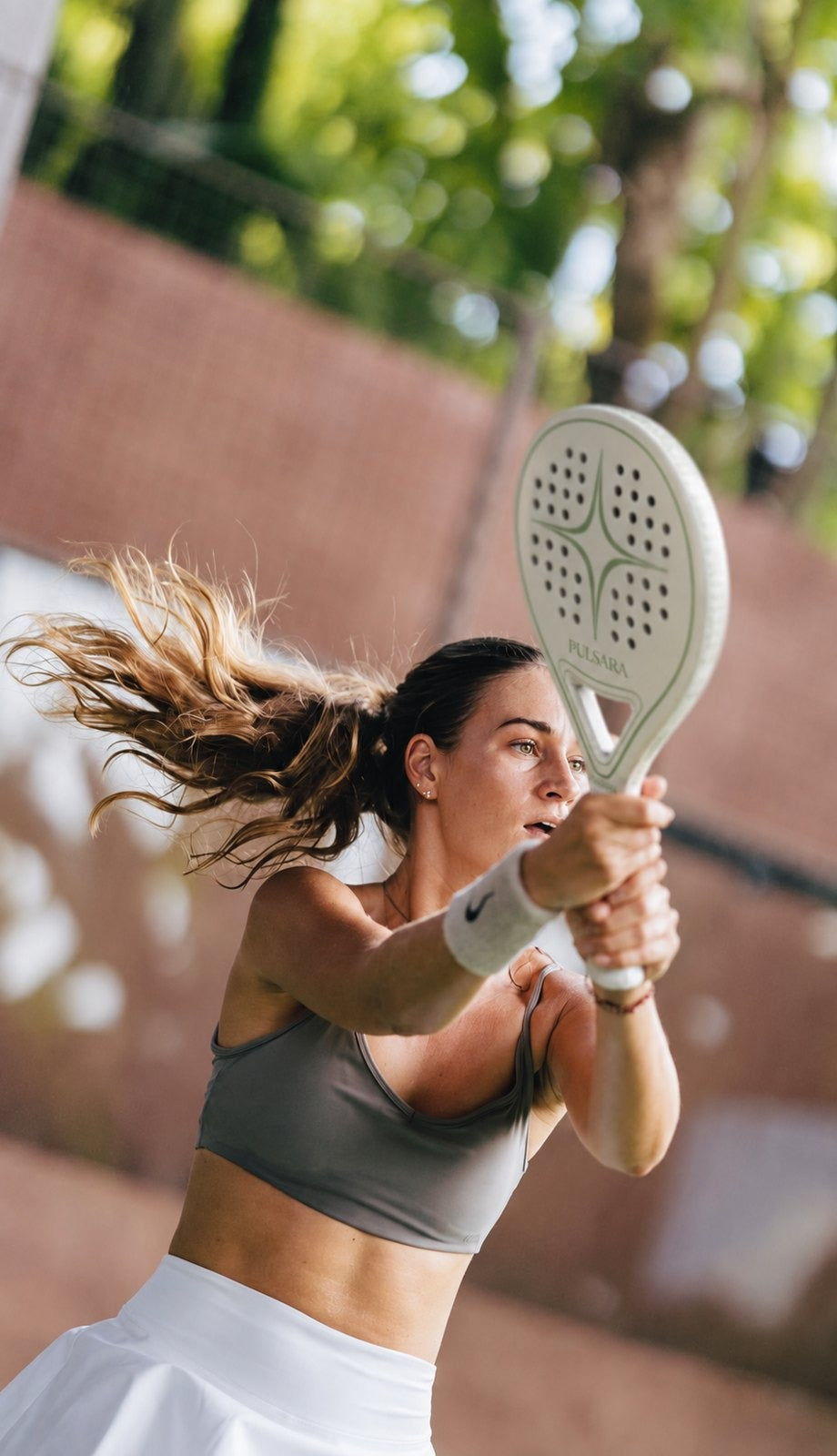 A player mid-swing with the Pulsara racket in Casiopea